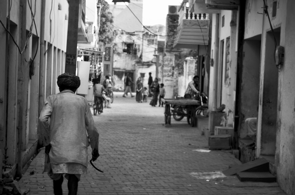 man walking down alley in india