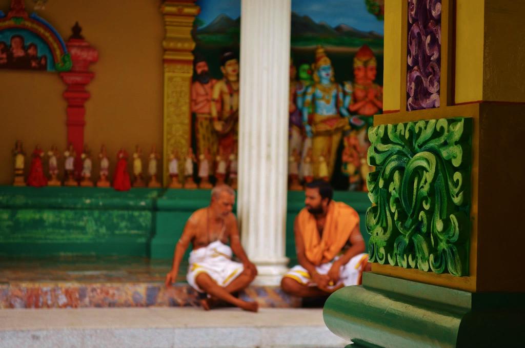 two men talking inside a temple